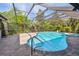 Screened-in pool area with lush landscaping and brick patio at 3398 Pinnacle S Ct, Palm Harbor, FL 34684
