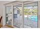 View of outdoor pool and patio area, accessible through sliding glass doors, perfect for entertaining at 3398 Pinnacle S Ct, Palm Harbor, FL 34684
