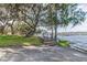 Picturesque waterfront featuring a charming walkway and a scenic dock with mature trees overhead at 3398 Pinnacle S Ct, Palm Harbor, FL 34684
