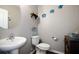 Well-lit half bathroom with pedestal sink, decorative turtles, and wood-look flooring at 5524 Yellowfin Ct, New Port Richey, FL 34652
