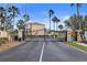 Gated entrance to the Sea Forest Townhomes with palm trees and tropical landscaping on a sunny day at 5524 Yellowfin Ct, New Port Richey, FL 34652