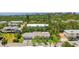 Aerial view showcases the home with its mature landscaping, waterfront, and a three-car garage at 636 Tarawitt Dr, Longboat Key, FL 34228