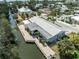 An aerial view showcases the home's waterfront location and extensive dock on a wide canal at 636 Tarawitt Dr, Longboat Key, FL 34228