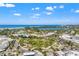 Aerial view showcasing the vibrant town center, lush park, and stunning ocean views under a beautiful sky at 636 Tarawitt Dr, Longboat Key, FL 34228