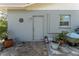 Home exterior with backyard stone patio, potted plants, grey paint, and garden hose at 636 Tarawitt Dr, Longboat Key, FL 34228