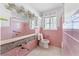 Retro pink-tiled bathroom with shower/tub and unique decor, awaiting renovation at 636 Tarawitt Dr, Longboat Key, FL 34228
