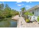 Back patio with tropical landscaping by the water, perfect for relaxation and enjoying the scenic view at 636 Tarawitt Dr, Longboat Key, FL 34228
