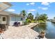 Outdoor patio area with stone tile and waterfront views along the canal, with chairs to relax at 636 Tarawitt Dr, Longboat Key, FL 34228