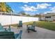 Outdoor backyard patio area with teal Adirondack chairs, green grass, and a white fence at 712 43Rd N Ave, St Petersburg, FL 33703