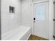 Bright bathroom with white marble tile, shower/tub combo, glass block window, and access to the outside at 712 43Rd N Ave, St Petersburg, FL 33703