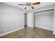 Bright bedroom features a ceiling fan, wood-look flooring, and closet with ample storage space at 712 43Rd N Ave, St Petersburg, FL 33703