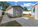 View of the detached garage featuring neutral stucco, decorative wall trellises and a concrete driveway on a sunny day at 712 43Rd N Ave, St Petersburg, FL 33703