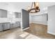 Open-concept kitchen with stainless steel appliances, shaker cabinets, and modern light fixtures at 712 43Rd N Ave, St Petersburg, FL 33703
