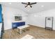 Bright living room with wood-look floors, a ceiling fan, TV, and a white and gold coffee table at 712 43Rd N Ave, St Petersburg, FL 33703