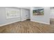 Bright living room with wood-look flooring, white trim, and view of the front yard at 712 43Rd N Ave, St Petersburg, FL 33703