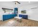 Open living space with wood-look floors, blue cabinets, a ceiling fan, and a TV at 712 43Rd N Ave, St Petersburg, FL 33703