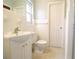 Bright bathroom with white tiled walls, a modern sink, and a classic toilet at 1001 Brookside Dr, Clearwater, FL 33764