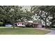 Charming single-story home featuring a brick driveway, mature trees, and a well-maintained lawn at 1001 Brookside Dr, Clearwater, FL 33764