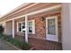 Inviting front porch with brick accents, decorative lighting, and a tiled entryway at 1001 Brookside Dr, Clearwater, FL 33764