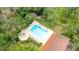 Overhead view of the community pool area, including lounge chairs and surrounding trees at 1012 Pearce Dr # 304, Clearwater, FL 33764