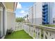 This balcony with artificial turf and a white railing looks out at another building on the property at 1012 Pearce Dr # 304, Clearwater, FL 33764