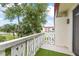 This balcony features a decorative white railing and a small green carpet, overlooking the community and a mature tree at 1012 Pearce Dr # 304, Clearwater, FL 33764