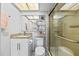 Bright bathroom showcasing a granite countertop, white cabinetry, and a glass-enclosed shower at 1012 Pearce Dr # 304, Clearwater, FL 33764