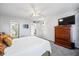 Cozy bedroom with a bed, dresser, ceiling fan, and view into the bathroom and dining room at 1012 Pearce Dr # 304, Clearwater, FL 33764