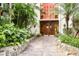 Inviting condo entrance with lush landscaping, stone pathway, and warm wood doors at 1012 Pearce Dr # 304, Clearwater, FL 33764