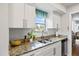 Bright kitchen featuring stainless steel appliances, granite counters, and white cabinetry at 1012 Pearce Dr # 304, Clearwater, FL 33764
