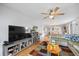 Bright living room featuring a ceiling fan, comfortable sofa, and entertainment center with large TV at 1012 Pearce Dr # 304, Clearwater, FL 33764