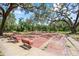 Community shuffleboard courts under the shade of mature trees, surrounded by benches at 1012 Pearce Dr # 304, Clearwater, FL 33764