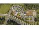 An aerial perspective exhibits the community's layout, farm plots, parking, and the integration of green spaces at 10242 Gentle Rain Dr, Land O Lakes, FL 34638