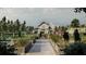 View of the community garden with raised garden beds, manicured brick pathways and decorative barn style clubhouse at 10242 Gentle Rain Dr, Land O Lakes, FL 34638