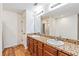 Bathroom features wood floors, double sinks with granite counters, and a large mirror with modern lighting at 11922 Winterset Cove Dr, Riverview, FL 33579
