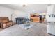 Open-concept living room boasts plush carpeting, a comfortable sofa, and easy access to the kitchen area at 11922 Winterset Cove Dr, Riverview, FL 33579