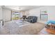 Bright living room features plush carpeting, a modern ceiling fan, and sliding glass doors to the backyard at 11922 Winterset Cove Dr, Riverview, FL 33579