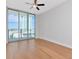 Bright, open living room featuring hardwood floors, fan, and sliding glass doors to balcony at 1208 E Kennedy Blvd # 1121, Tampa, FL 33602