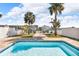 Backyard featuring a sparkling pool, lush palm trees, and waterfront access, creating a serene outdoor retreat at 12312 Lagoon Ln, Treasure Island, FL 33706