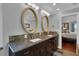 Bathroom with dual sinks, granite countertops, decorative mirrors, and access to the bedroom at 12312 Lagoon Ln, Treasure Island, FL 33706