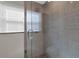 Bathroom shower features tile, pebbled floor, glass door and a window at 12312 Lagoon Ln, Treasure Island, FL 33706