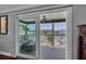 Sliding glass doors open to a peaceful balcony with waterfront views and comfortable seating and table at 12312 Lagoon Ln, Treasure Island, FL 33706