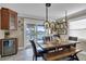 Dining room featuring stylish lighting, a rustic table, and access to outdoor balcony with water views at 12312 Lagoon Ln, Treasure Island, FL 33706