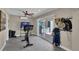 Bright exercise room featuring a modern ceiling fan, tiled floors, exercise bike, and sliding glass doors at 12312 Lagoon Ln, Treasure Island, FL 33706