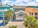 Charming two-story home with a front-facing garage, well-maintained yard, and lush palm trees at 12312 Lagoon Ln, Treasure Island, FL 33706