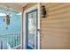Close-up of front door with glass detailing, modern light fixture, and blue trim at 12312 Lagoon Ln, Treasure Island, FL 33706