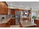 Bright kitchen featuring a stainless steel refrigerator, wooden cabinetry, and stylish countertops at 12312 Lagoon Ln, Treasure Island, FL 33706
