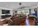 Bright living room featuring a large window, hardwood floors, sectional couch and a pinball machine at 12312 Lagoon Ln, Treasure Island, FL 33706
