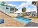 Inviting pool area with brick paver patio and a glimpse of the canal, perfect for outdoor relaxation and waterfront enjoyment at 12312 Lagoon Ln, Treasure Island, FL 33706