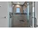 Modern shower with a glass enclosure, multiple shower heads, a built-in seat and tiled accents at 12312 Lagoon Ln, Treasure Island, FL 33706